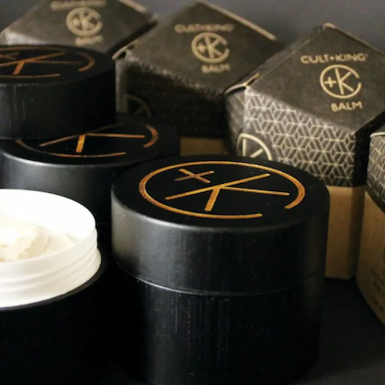 multiple black bamboo mini jars of balm and their cardboard obelisk packaging.