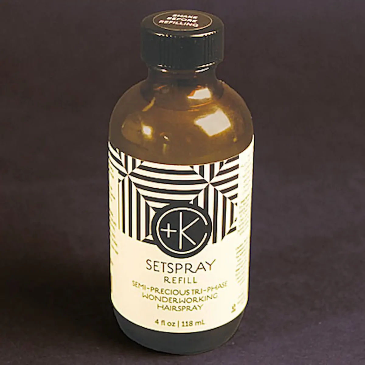 a brown apothecary bottle with a black and white label and some cool repeating lines and the c+k logo.