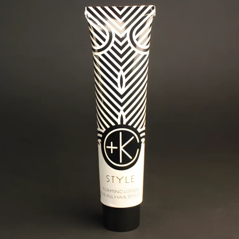 a white aluminum tube with black writing and lines with the c+k logo and a black lid is on a black backdrop.