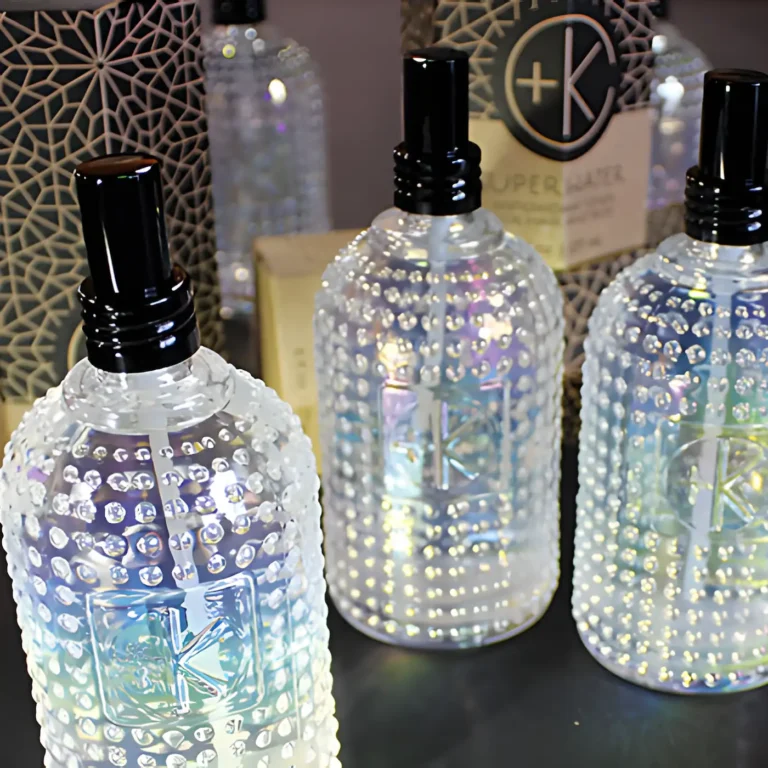 multiple bottles of holographic glass with beaded accents and a black sprayer in front of cardboard pacaging.