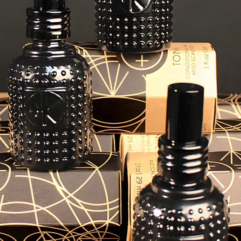 a close up of a few mini bottles of tonik. they are black bottles with little dots the bottles are glass and have black lids and are perched on their obelsk cardboard packaging.