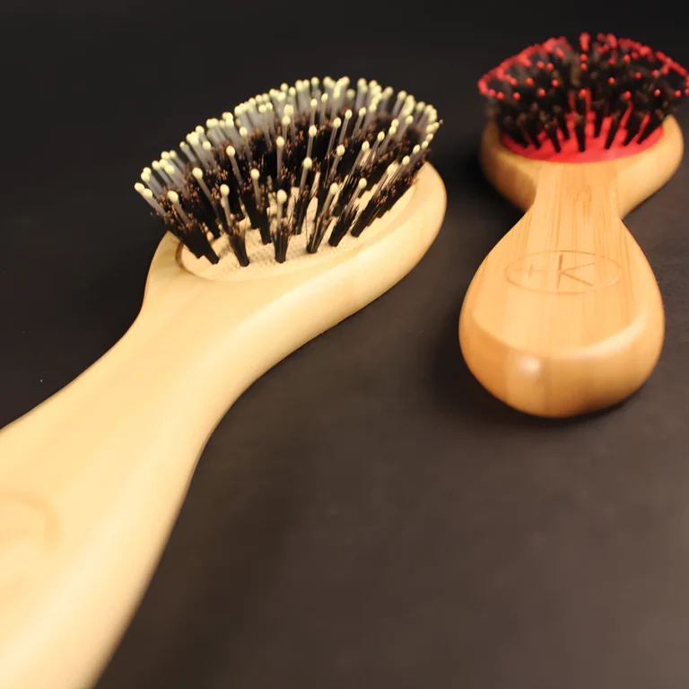 2 light bamboo boar bristle brushes, one red, one yellow.