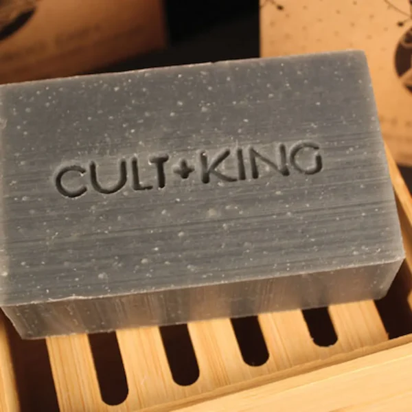 Cult+King Wash bar soap on bamboo tray with embossed logo, close-up view.