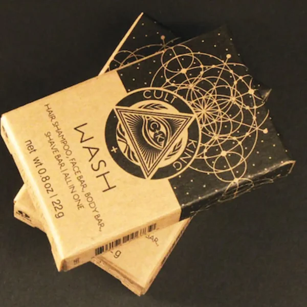 2 small boxes are stacked and showing the label from cult + king. it is a shampoo bar in a cardboard box with alchemical symbols.