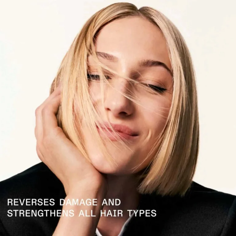 Blonde woman with sleek bob smiling, showing smooth healthy hair after repair treatment.