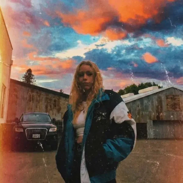 erin wears a vintage sharks pro line jacket under a blue and orange sky