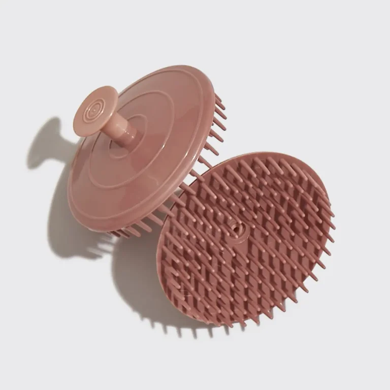 2 views of a terracotta colored exfoliating scalp brush.