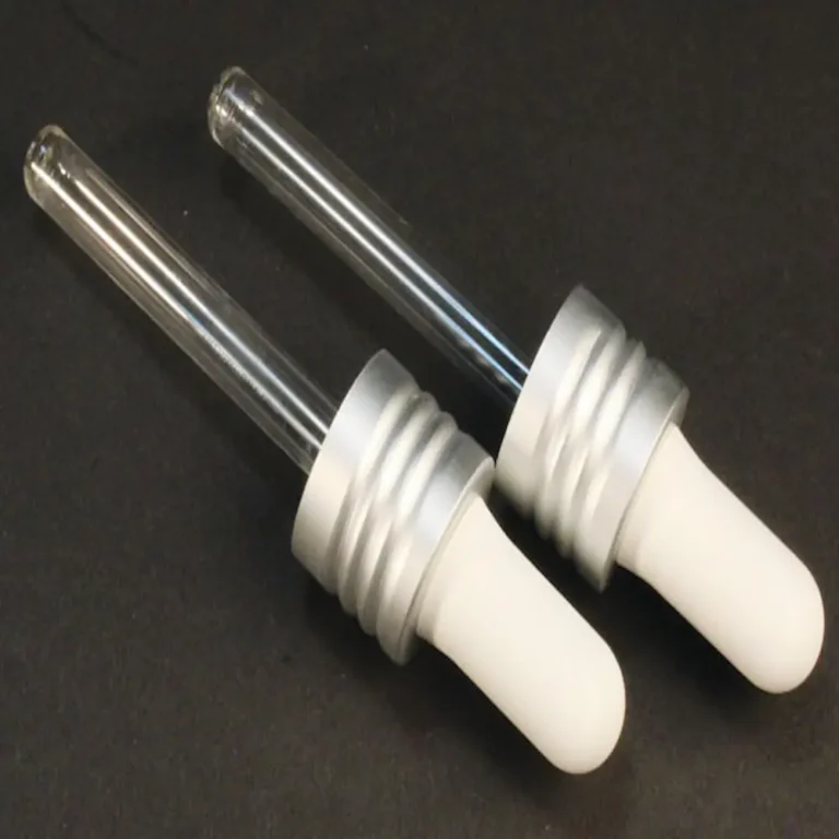 2 replacement glass droppers for mini jelly from cult + king on a black background. the rubber squeezer on top is white and the glass is clear.