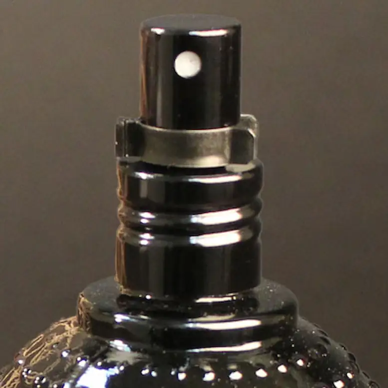 a black sprayer for a tonik bottle with a black background.