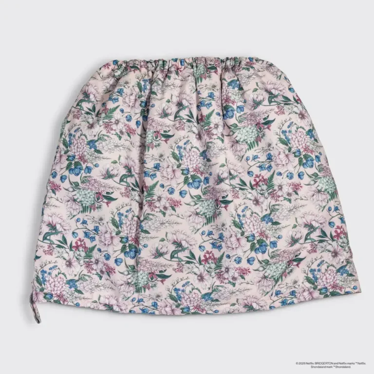 a flatlay of the flexi cap from the kitsch x bridgerton collection showing the pattern of blue flowers on a white background