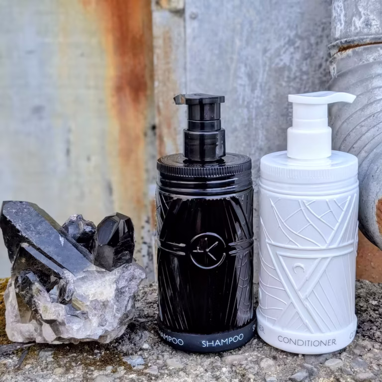 a fat smokey quartz with peaks with a set of opaqque black and white glass wide mouth shampoo and conditioner, astral amino