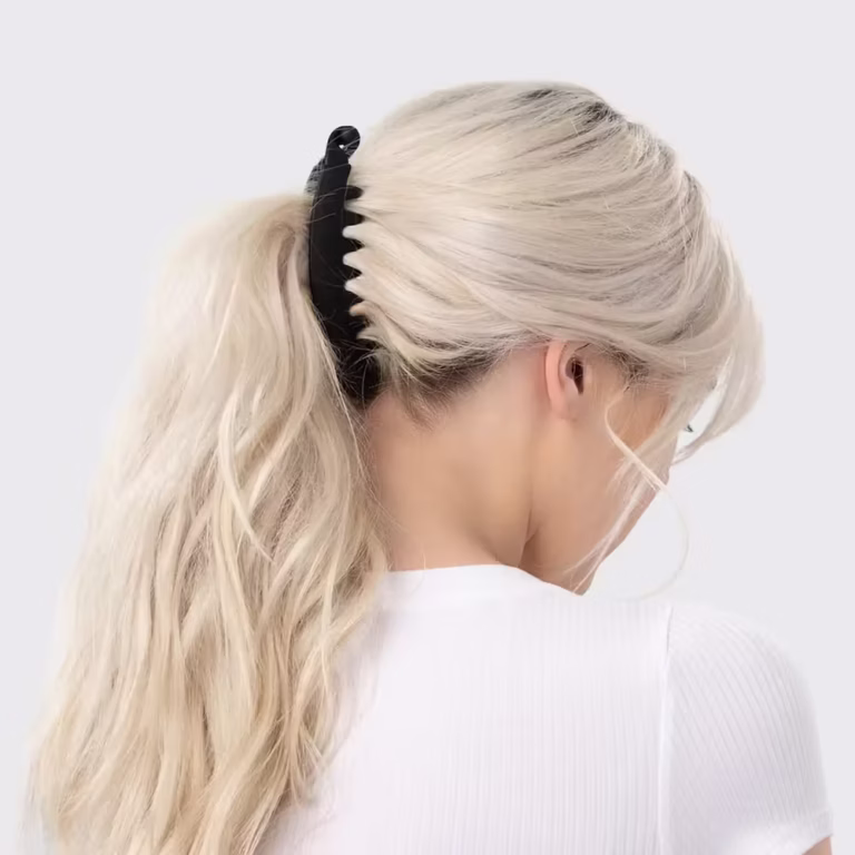 A black banana clip holding long blonde hair in a ponytail