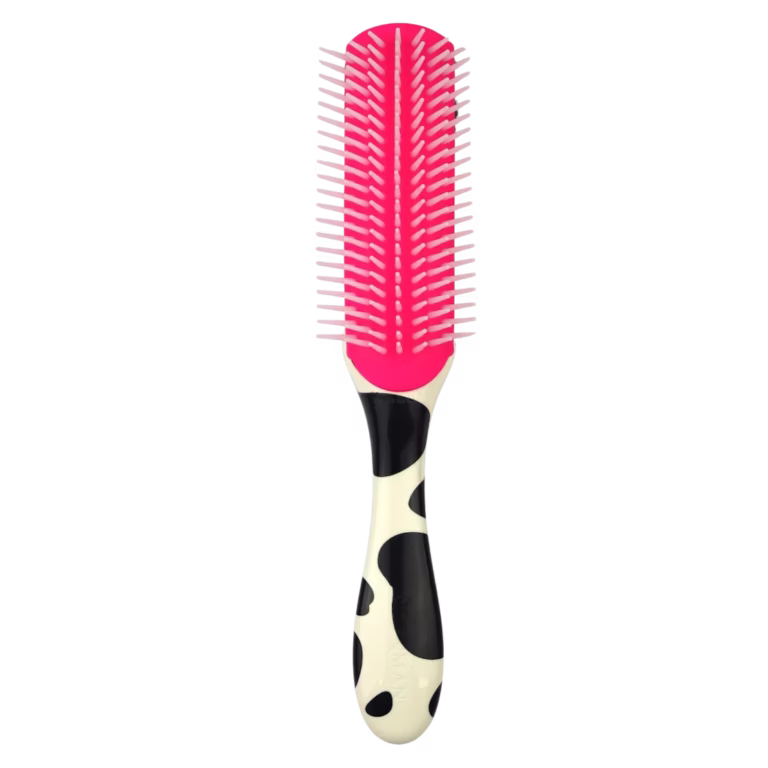Front view of the Denman D3 Deluxe curly hair styling brush in Cow print, showing a black and white spotted handle, a bright pink rubber cushion pad, and seven rows of pink nylon pins.