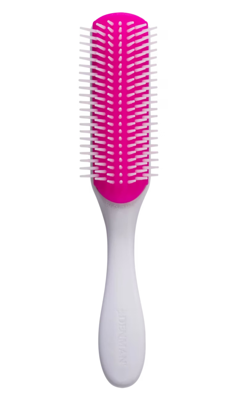 Front view of the Kyoto Cherry Blossom Denman D3 brush showing a white handle, a vibrant magenta-pink rubber pad, and seven rows of smooth white nylon pins for curl definition.